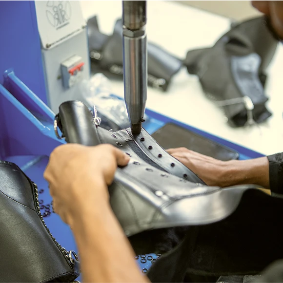 Leather boot upper being shaped on a lasting machine at Foot On Shoes