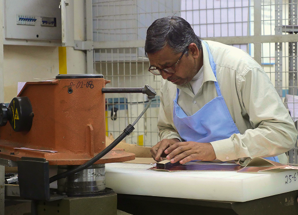 Pattern cutter preparing leather components at the Foot On Shoes factory
